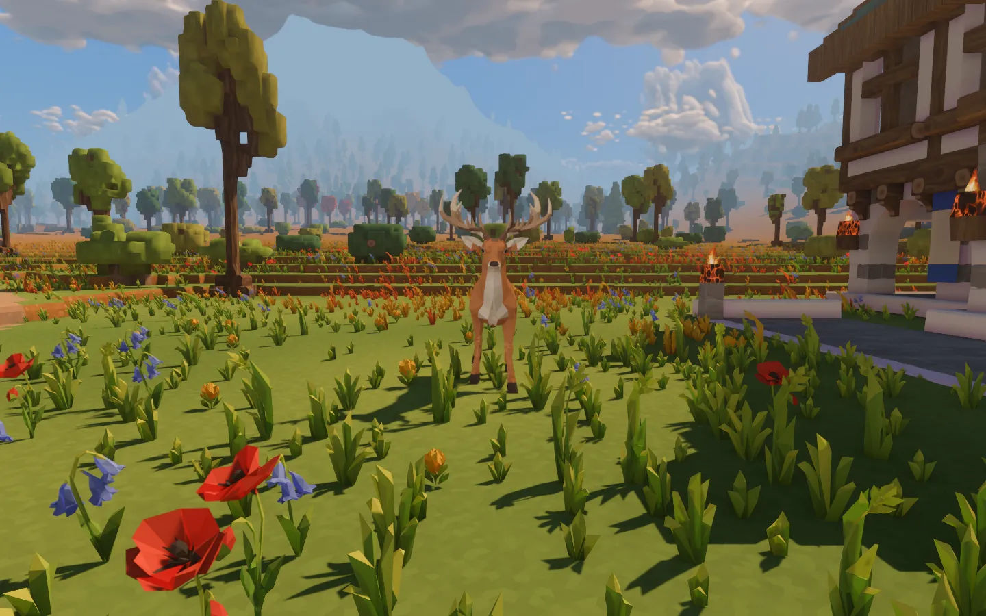 The antlered deer facing the camera on the flowered green, with the hall at its side and the forest beyond.