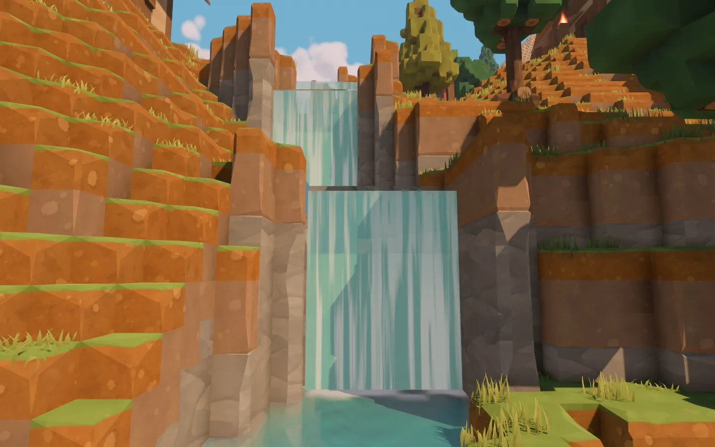 A turquoise waterfall spilling between rocky banks into the village river beneath the trees.