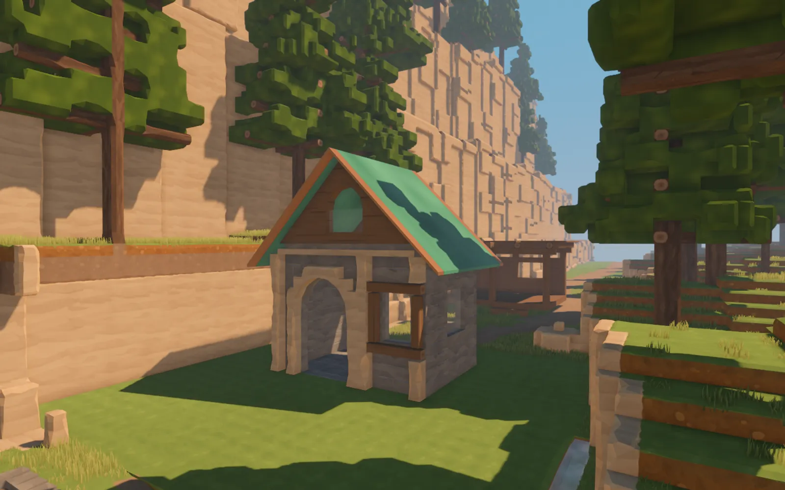 An experimental stone gatehouse with a green copper roof, timber-framed window and arched doorway beneath sandstone cliffs.