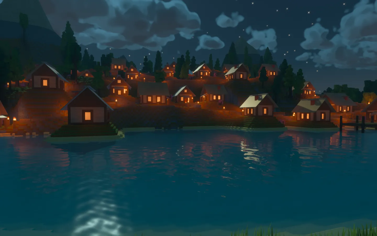 The village under moonlight, with warm cottage and path lights across the hillside and reflections on the lake.