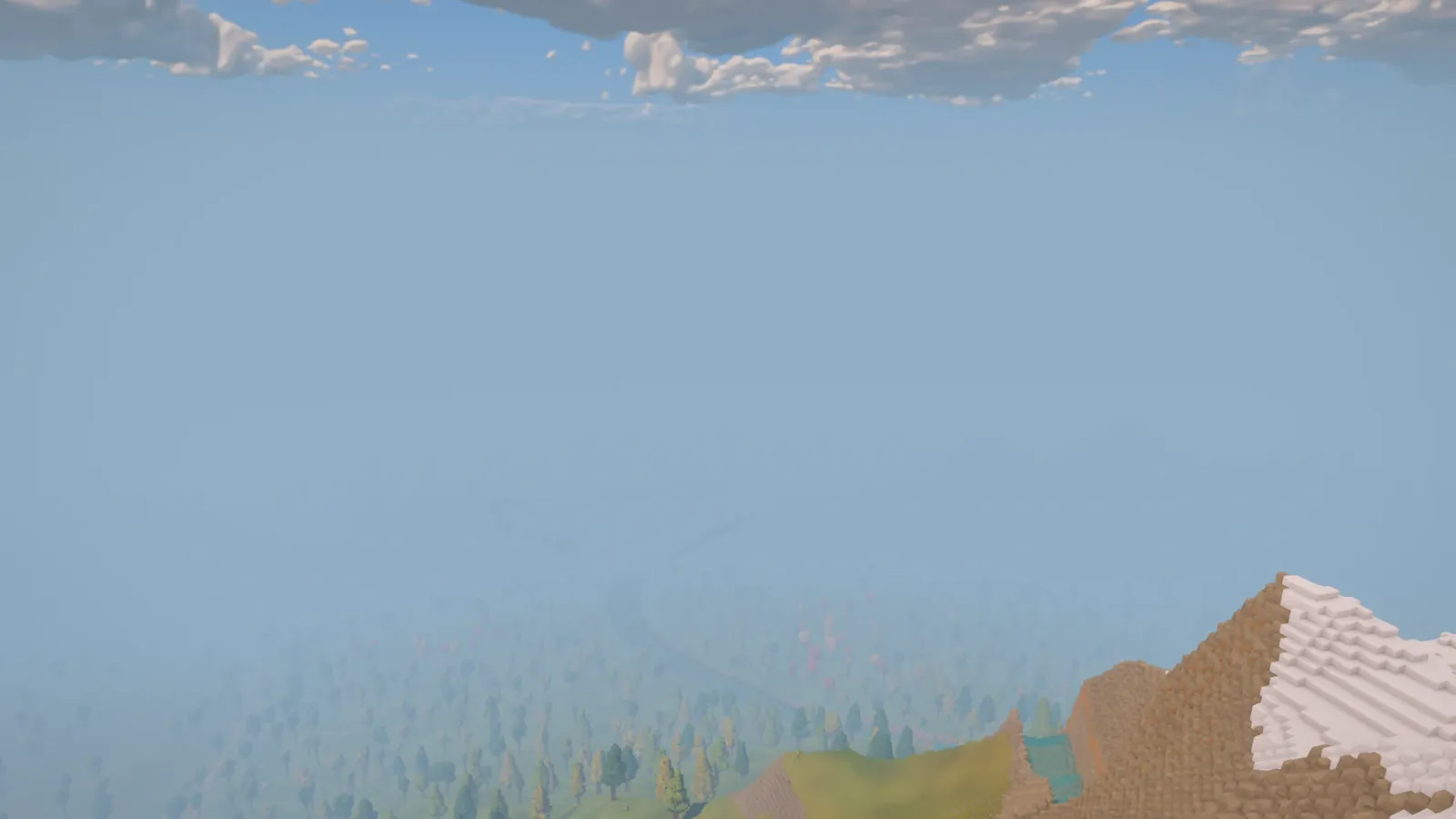 Before the skyline update, dense haze hides most of the valley below the snowy summit, with only nearby trees and the mountainside visible.