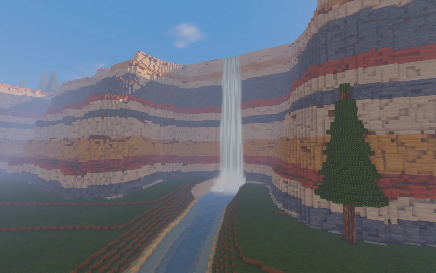 The early waterfall descending from the sandstone cliffs into its pool.